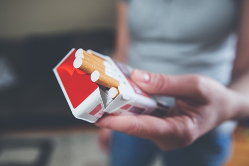 Female hands hold pack of cigarettes , prepare for smoking cigarette