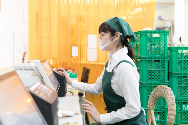 スーパーの裏方で働く人々 値札ラベル作成